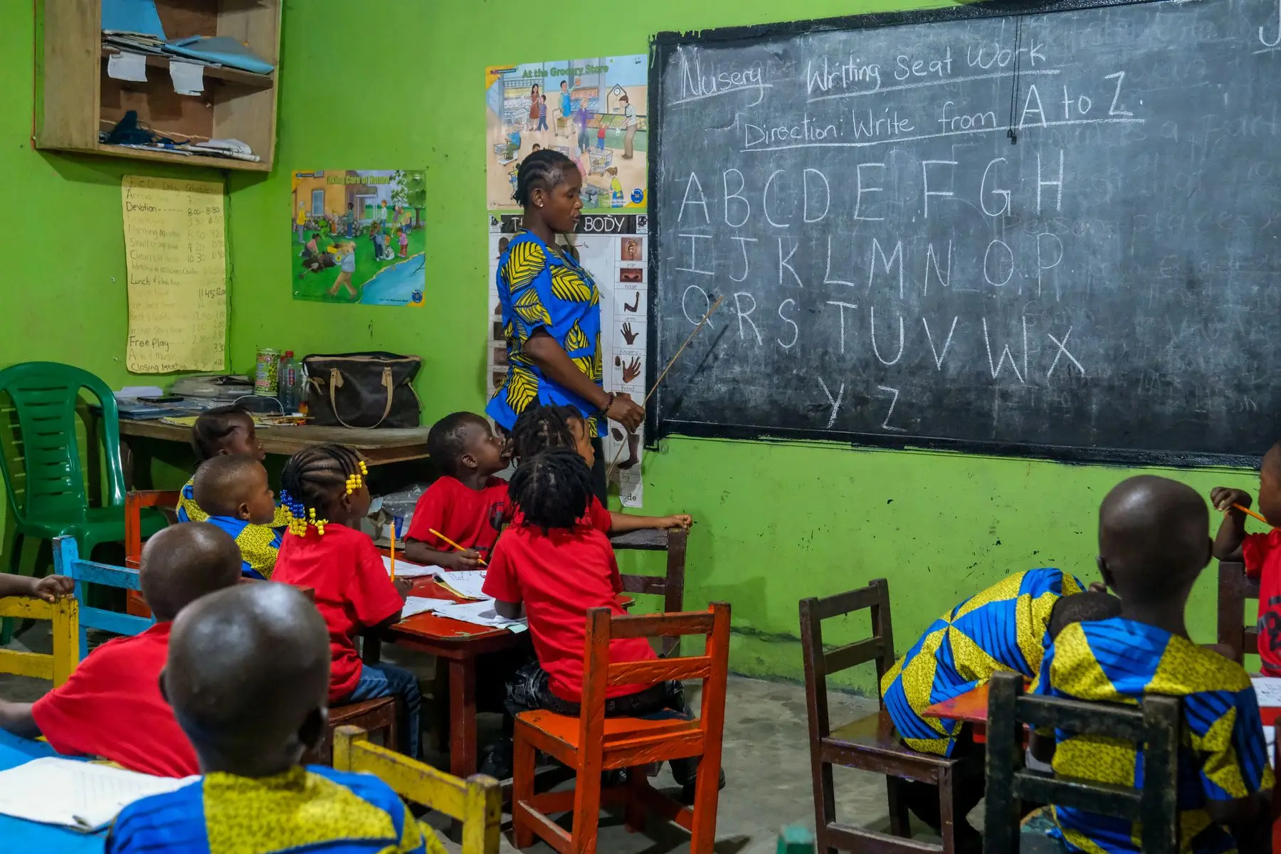 A teacher writing at a blackboard during a lesson